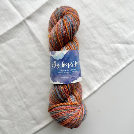 Multicolored skein of yarn with a label on a textured white background