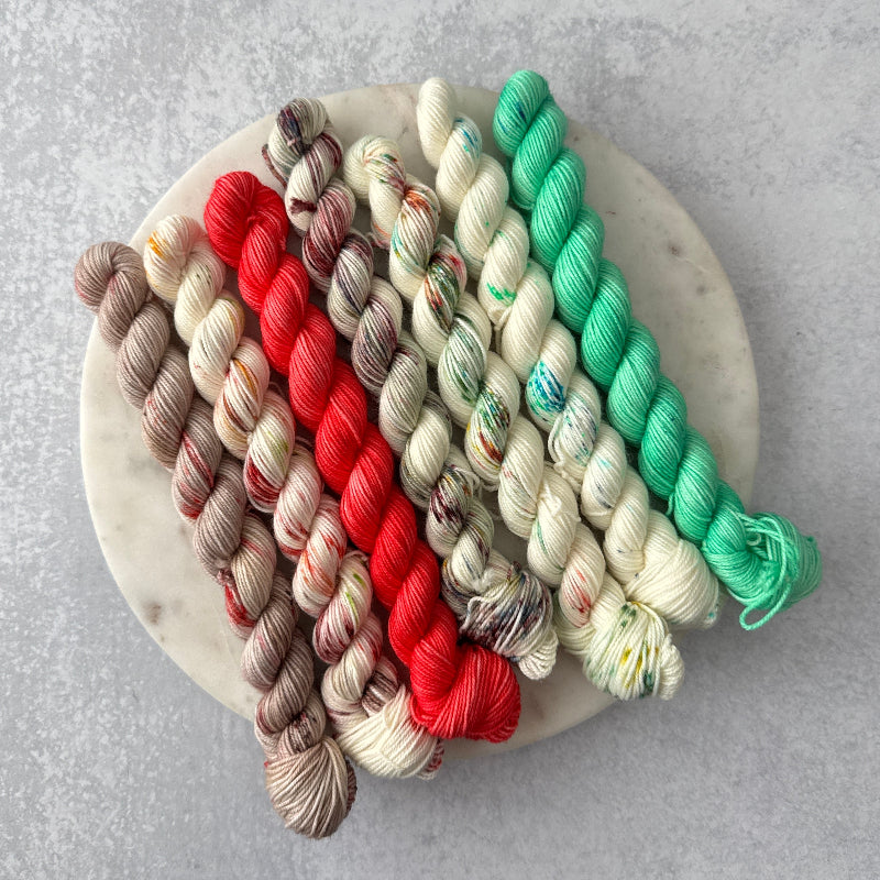 Colorful yarn skeins arranged on a marble surface with a gray background
