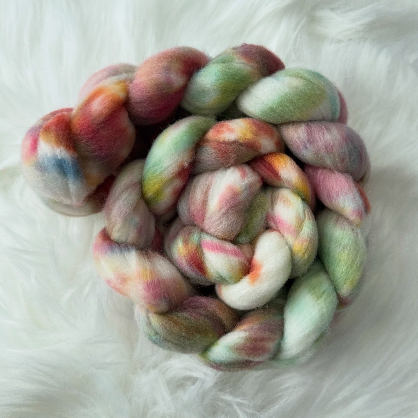 Colorful braided yarn on a white fluffy surface